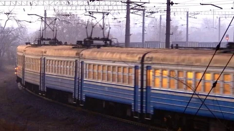 Structure of the cargo train on turn with a passenger electric train night Stock Footage 74958931