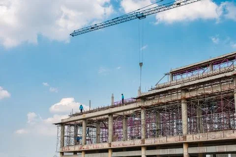 Structure of large building with worker working, crane and scaffold in constr Stock Photos