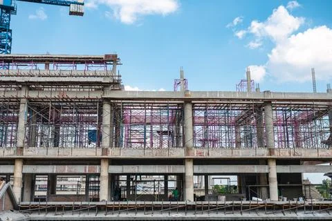 Structure of large building with worker working, crane and scaffold in constr Fotos de archivo