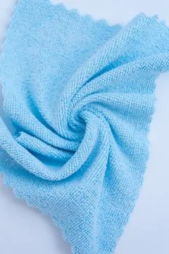 Structure of a microfiber shopping rag. Blue rag on a white background close-up. Stock Photos