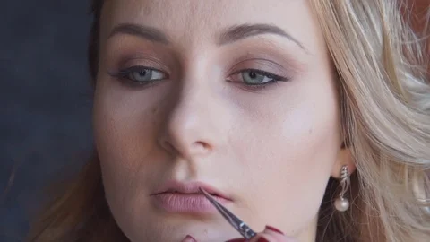 Structuring procedure.Make-up artist puts foundation on the face of the young Vídeos de archivo 69922351