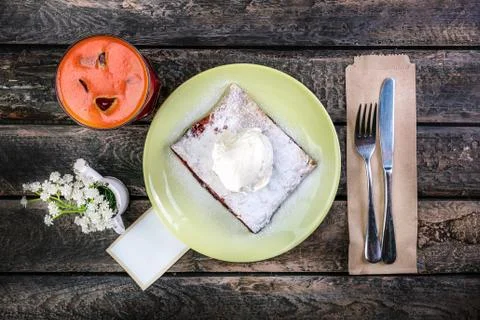 Strudel with cherry , served on the ceramic plate with the ice cream,cutlery and Stock-Fotos