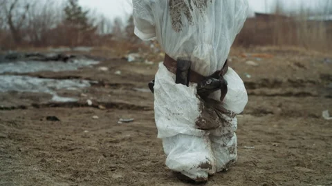 Struggling figure moves carefully through toxic landscape. Weary individual Stock Footage 346462243