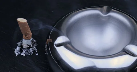 Stubbed cigarette butt stub with ash on black background Stock Footage 129550720