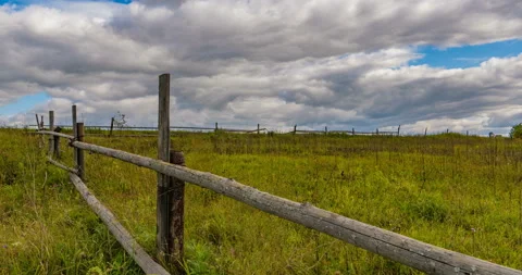 Stubble field with straw bales under blue sky with cirrus clouds. 4k timelapse Stock Footage 117339654