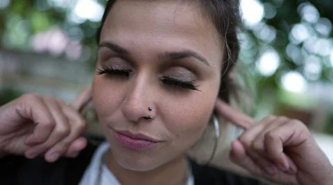 Stubborn person avoiding commentary putting finger inside ear not wanting to  Stock Photos