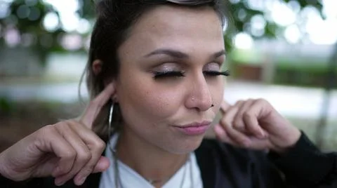 Stubborn person avoiding commentary putting finger inside ear not wanting to  Stock Photos