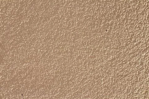 Stucco wall texture background in warm beige tone with rough plaster finish 스톡 사진