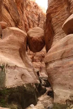 Stuck big rock hovering over the trail through the Wadi Ghuweir Canyon, ,Da.. Stock Photos
