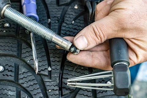 Stud insertion into studding tool for tire repair Stock Photos