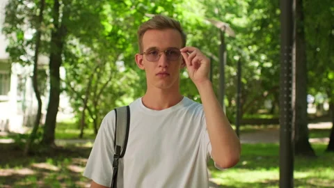 Student adjusting his glasses outside. Man on campus in college wearing gla.. Stock-Footage 339525218