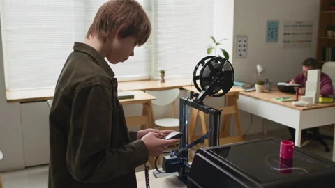 Student Adjusting Print Dettings on Control Screen in Front of 3D Printers Stock Footage 335690164