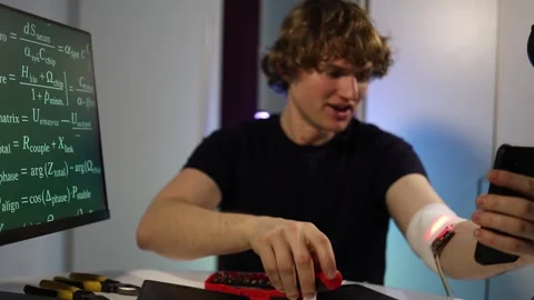 Student adjusts wearable device during biohacking test Stock Footage 324443681