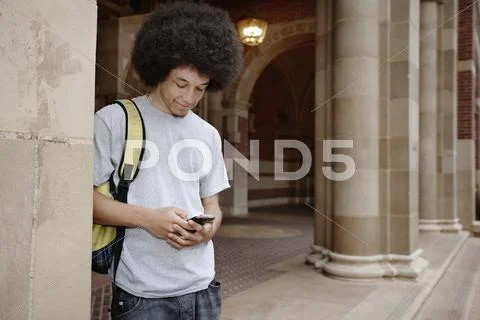 Student With Afro Text Messaging On Cell Phone