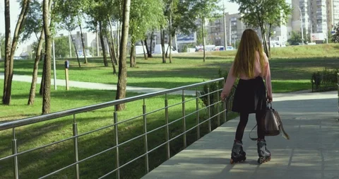 Student after school roller skates in a city park Stock Footage 115079769