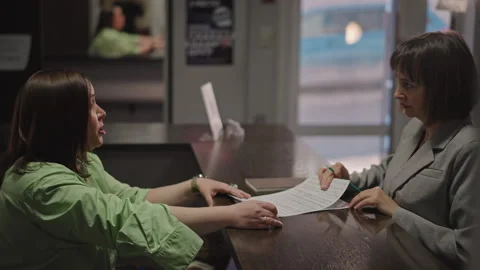 Student and coach paperwork review. Reception area where student and instructor Stock Footage 346561868