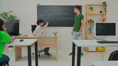 Student and Instructor Discuss Python Code in Modern Classroom Stock Footage 281072408