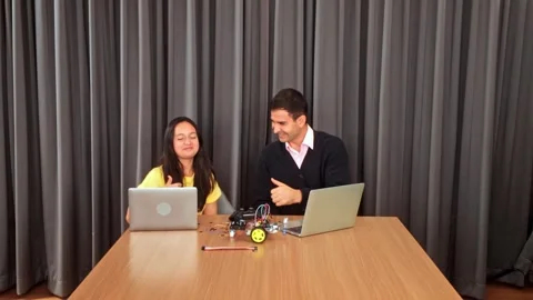 Student and teacher work on a robotics project with laptops in a classroom. Stock-Footage 312192895