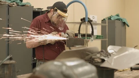 Student apprentice cutting metal with a grinder in a trade school workshop Stock Footage 125068979