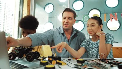 Student asking teacher about code and pointing at laptop screen. Edification. Foto stock