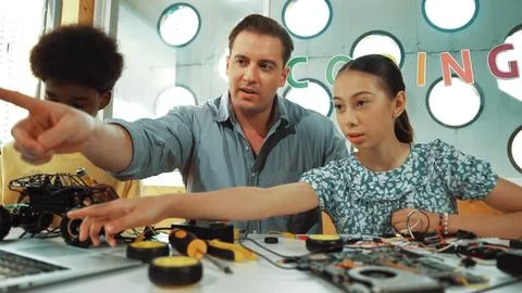 Student asking teacher about code and pointing at laptop screen. Edification. Stock Photos