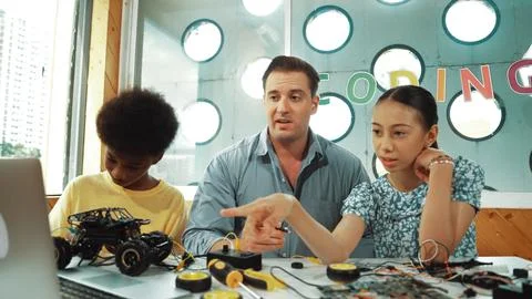 Student asking teacher about code and pointing at laptop screen. Edification. Stock Photos