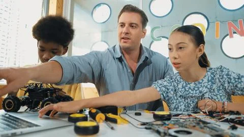 Student asking teacher about code and pointing at laptop screen. Edification. Stock Photos