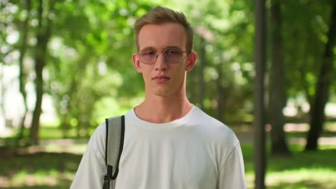 Student with a backpack and glasses on university campus. Man enjoying outd.. Stock Footage 339523072