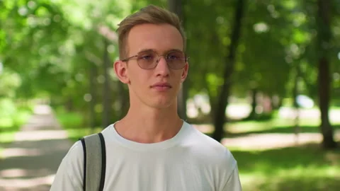 Student with a backpack and glasses on university campus. Man enjoying outd.. Stock Footage 339523198