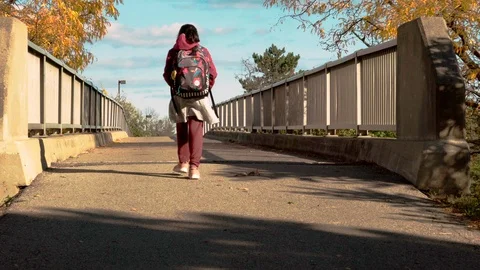 Student with backpack crossing bridge. A7R369 Stock Footage 96772801