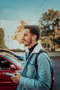 A student with a backpack using a smartphone on the street, checking email Stock Photos