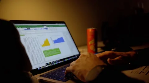 Student behind computer in dark room with excel sheet Stock Footage 219854085