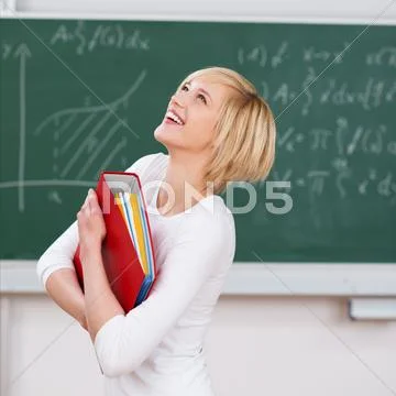 Student with binder looking up against chalkboard Stock Photos