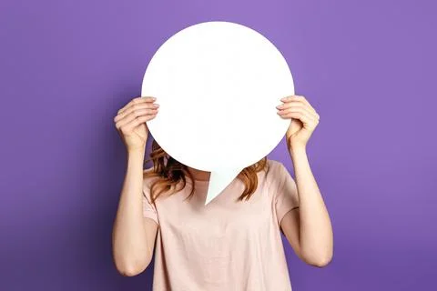 Student with blank white speech bubble isolated on purple studio background.  Stock Photos