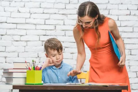 Student boy doing work in school supervised by his teacher Foto stock