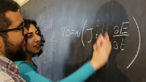 Student boy getting a physics lecture from his young lady teacher Video stock 124664365