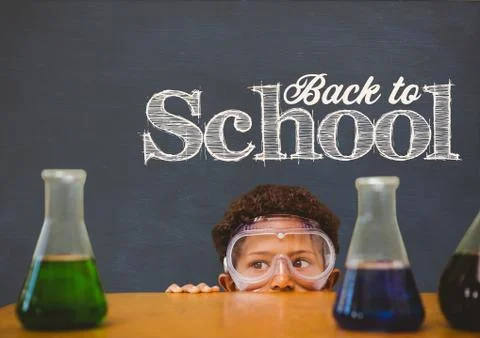Student boy hiding behind a table against blue blackboard with back to school 스톡 사진