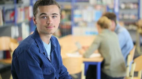 Student boy sitting on table in library room Stock Footage 51573866