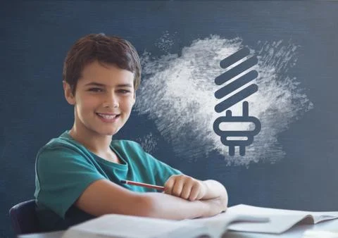 Student boy at table against blue blackboard with school and education graphic Stock Photos