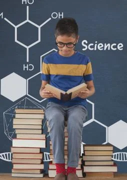 Student boy on a table reading against blue blackboard with science text and Stock Photos
