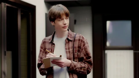 Student boy writing notes in notepad during study break in university campus Video stock 120409410