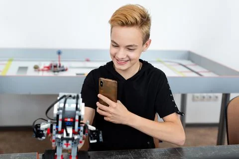 Student builds a robot constructor from plastic parts programmed on a computer Stock Photos