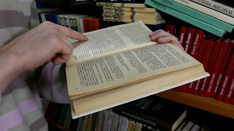 Student carefully reads a book in the library Stock Footage 86565391