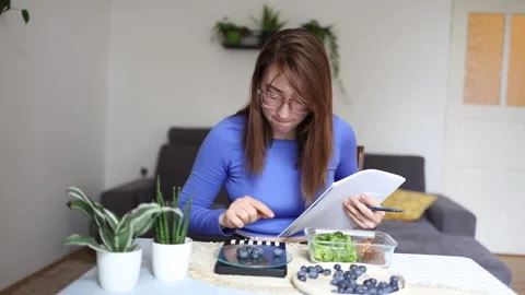 Student carefully records meals during a diet Vidéo 341236349