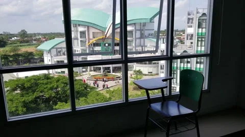 Student chair through the window facing the campus building Stock Footage 218231324