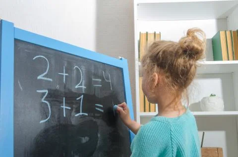 The student on the chalk Board decides examples 库存照片