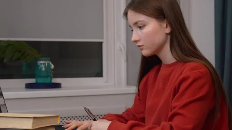 Student changing posture while studying at home Stock Footage 311815147