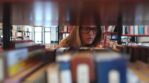 Student chooses a book in the library Stock Footage 68137098