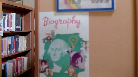 Student choosing a library book from a high school library shelf Stock Footage 59533454