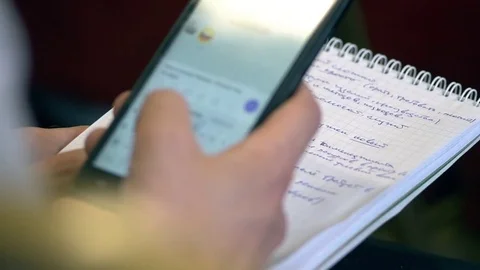 Student in class in College writes a message to the smartphone Stock Footage 76246760